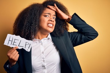 Young african american business woman with afro hair holding help paper for work stress stressed...