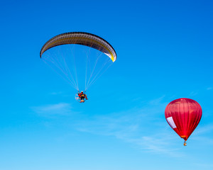 Baloon with moto glider in the blue sky