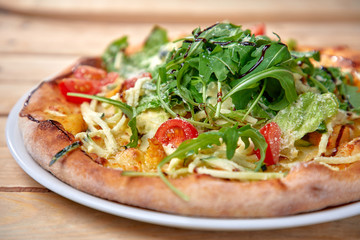 pizza with fresh vegetables on the wooden background