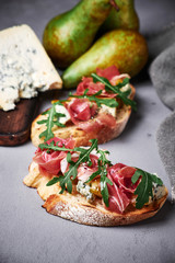 bruschetta with gorgonzola cheese, smoked meat, arugula
