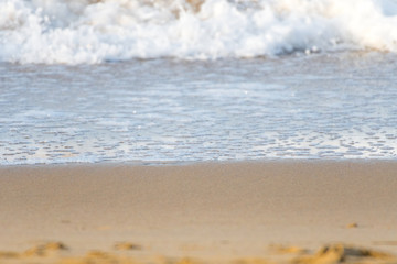 The foam of a wave reaching the sandy coast