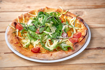 pizza with fresh vegetables on the wooden background