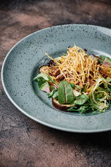warm meat salad with fried potatoes and sprinkled with gravy and adding rosemary,radish