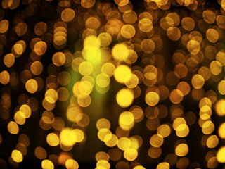 Golden bokeh on dark background. Glowing light effect. Gold abstract blurred background. Yellow bokeh wallpaper