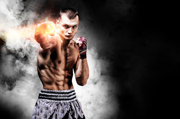 Thai boxer stands in the ring and punches in front of him. The concept of sports, gyms, boxing...