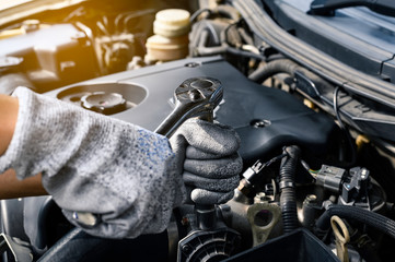 Auto mechanic working on car engine in mechanics garage. Repair service. authentic close-up shot