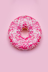 Donuts with icing on pastel pink background.