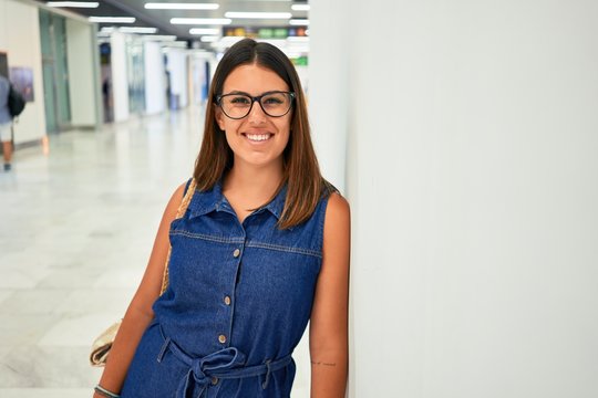 Young traveller woman at the airport going on vacation leaning on the wall