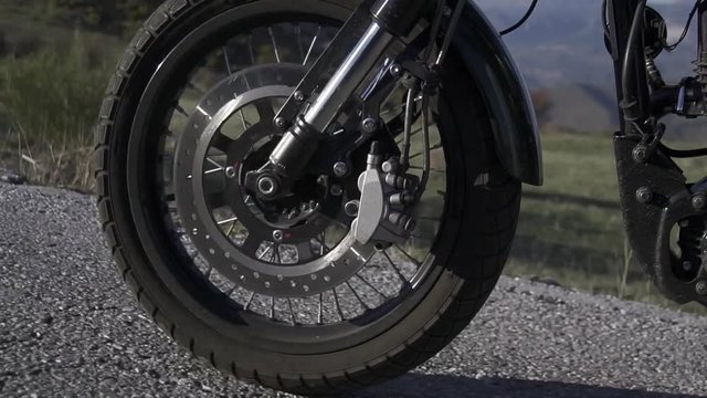 Rueda delantera de motocicleta en asfalto entre naturaleza y monta&ntilde;as HD