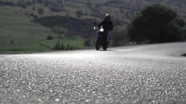 Motorista conduciendo motocicleta en una curva entre monta&ntilde;as y naturaleza HD