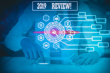 Writing note showing 2019 Review. Business concept for remembering past year events main actions or good shows Woman wear formal work suit present using smart latest device