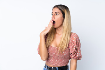 Fototapeta premium Young Uruguayan woman over isolated white background yawning and covering wide open mouth with hand