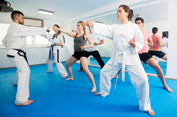 Fototapeta na wymiar Adults trying new martial moves at karate class