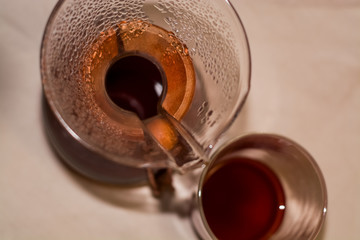 Chemex with strong and fresh black coffee of beans arabica stands on light coarse cloth. Alternative brew way. Filter.