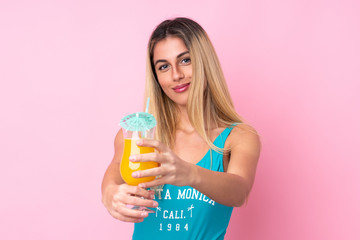 Young blonde Uruguayan woman in swimsuit in summer holidays over isolated pink background
