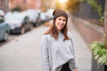 Fototapeta premium Young beautiful woman smiling happy and confident. Standing with smile on face walking at the city