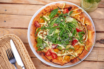 pizza with fresh vegetables on the wooden background