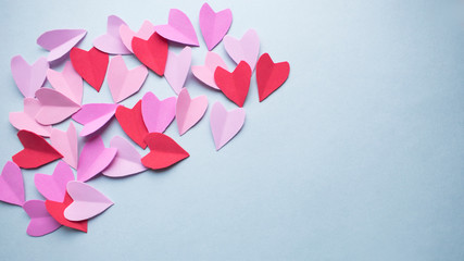 Valentines day background.  Pastel red pink purple lilac hearts on a blue background. Copy space.