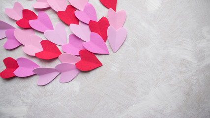Valentines day background. Pastel red pink purple lilac hearts on a light texture background. Copy space.