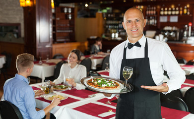 Fototapeta na wymiar Waiter with serving tray meeting guests