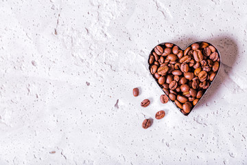 Heart-shaped coffee beans copy space on concrete background