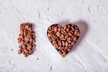 Letter and heart made of coffee beans on a concrete background.