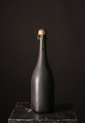 old bottle of red wine on a black background