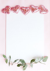 Background with copy space blank on pink background with pink glittered hearts, eucalyptus branch. White paper top view, flat lay, minimal style. Moke up card.