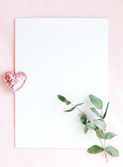 Background with copy space blank on pink background with pink glittered hearts, eucalyptus branch. White paper top view, flat lay, minimal style. Moke up card.