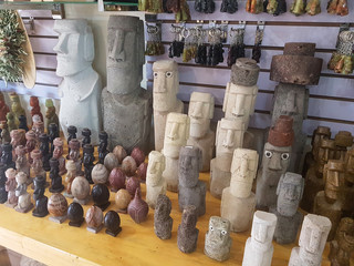 CLOSE UP: Small moai souvenir sculptures are set on the desk of a tourist shop.
