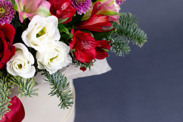 Fototapeta na wymiar floral fresh arrangement of bright flowers in a hat box gray background copy space