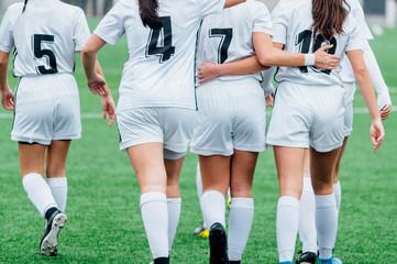 Unrecognizable female soccer players playing a game on the soccer field. © karrastock