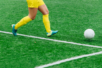 Unrecognizable female soccer players playing a game on the soccer field.