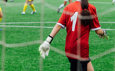 Unrecognizable female soccer players playing a game on the soccer field. © karrastock