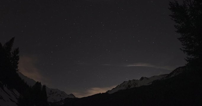 Zeitraffer eines Nachthimmels in den Bergen im Winter vom Sternenhimmel zum Mondaufgang