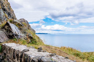 The Cliff Walk Bray to Greystones with beautiful coastline, cliffs, boulder stone wall and turquoise sea, Ireland