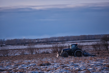 tractor in the field arable land winter agribusiness landscape seasonal work in a snowy field