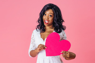 Portrait of an  young sexy woman holding pink heart with mouth open, valentineÕs day love