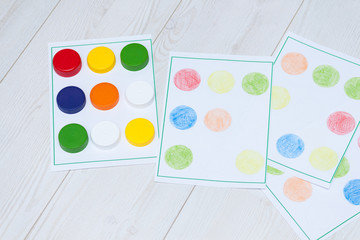 Handmade kids games with plastic caps for education, learning and motor skills. Craft for kids.