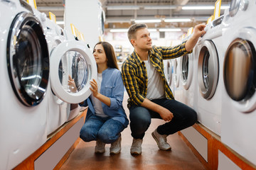 Couple choosing washing machine, electronics store - obrazy, fototapety, plakaty