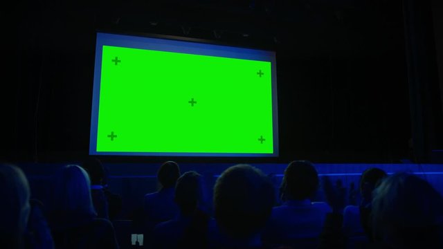 In Movie Theater Captivated Audience Applauds after Watching New Blockbuster Film on Mock-up Green Screen. People Watching Game Tournament Streaming, Live Concert Video, New Product Release Trailer