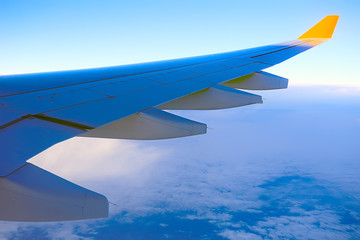 wing airplane view of sky / blue sky and wing of an airplane, view from the cabin of an airplane, concept of air transport