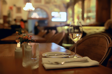 glass of white wine in the restaurant / white wine in the interior of the restaurant a table with glasses of wine, a romantic summer