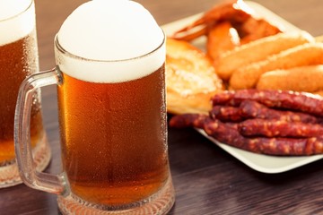 Beer glass alcohol drink with food sausage,  grilled background.