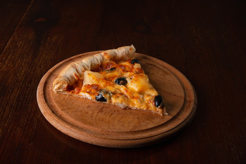 Pizza on a wooden dark background in a bar