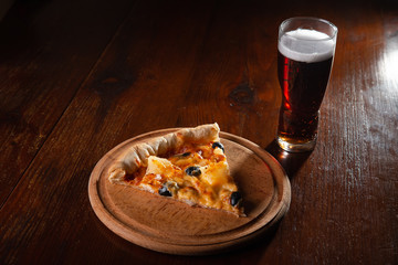 Pizza on a wooden dark background in a bar