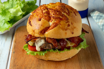 Bacon Cheese Burger with tomato, lettuce and a drop of mayonnaise.