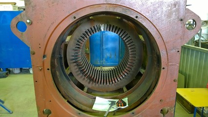 Old Electric motor repair. Winding replacement. Welded steel housing, stator core. Workshop at the...