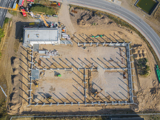 a drone photograph of a construction site with concrete supports for a factory building