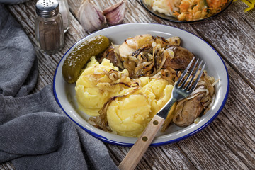 Fried liver with onion and apple, served with boiled potatoes and pickled cucumber.